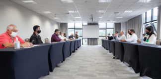 Empregadores e trabalhadores em reunião presencial na FIESC, com distanciamento social e máscaras.