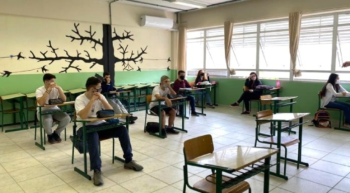 calendário escolar estadual - alunos sentados em carteiras separadas usando máscara dentro de sala de aula