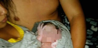 mãe dá à luz na sc 401 - a foto mostra ela com o bebê embrulhado no colo, com rosto censurado