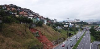 via expressa é liberada após deslizamento - foto área mostra parte do morro que desabou e rodovia com fluxo normal