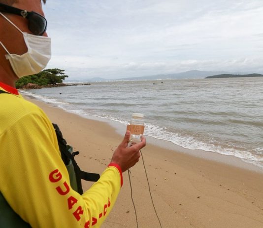 bombeiro faz coleta de água em praia para verificar índice de poluição nos pontos do litoral