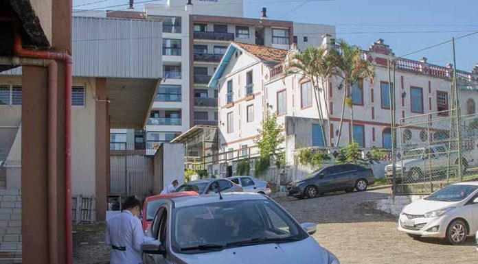 drive-thru de vacinação no primeiro de junho com profissional de saúde ao lado de carro para vacinar idosos em são josé