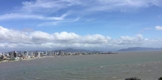 céu azul com nuvens brancas, prédios ao fundo e mar, onde deve se desenvolver o transporte marítimo da Grande Florianópolis - licitação do transporte marítimo em estudo