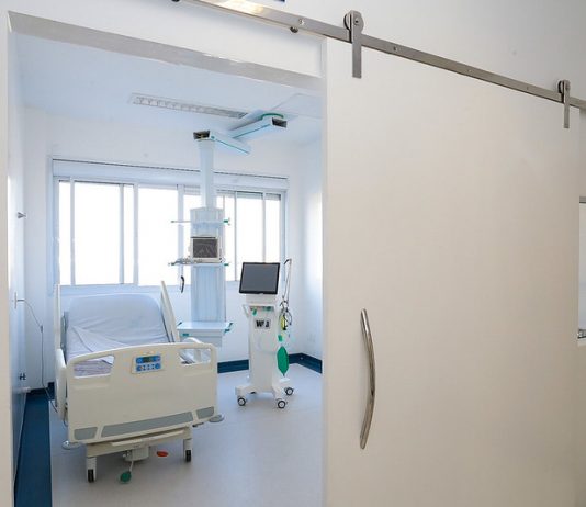 leito de uti vazio visto de fora da sala - governo suspende cirurgias eletivas para desafogar hospitais