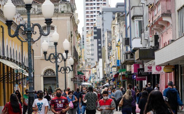 diversas pessoas andando de máscara pelo centro de florianópolis, ao lado do mercado público