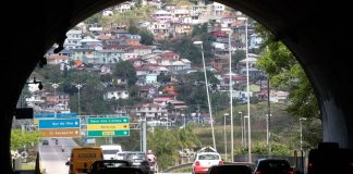 túnel antonieta de barros visto de dentro com carros passando e casas no morro ao fundo