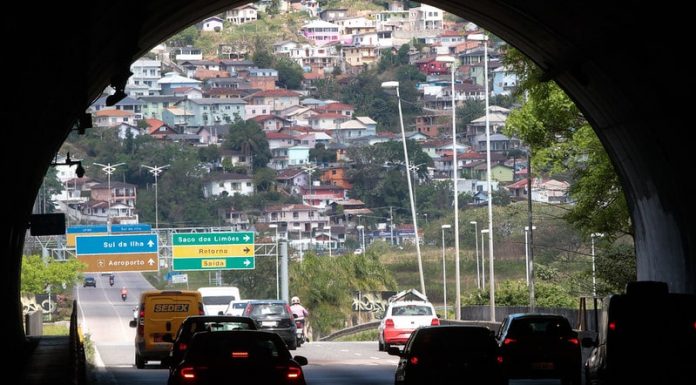 túnel antonieta de barros visto de dentro com carros passando e casas no morro ao fundo