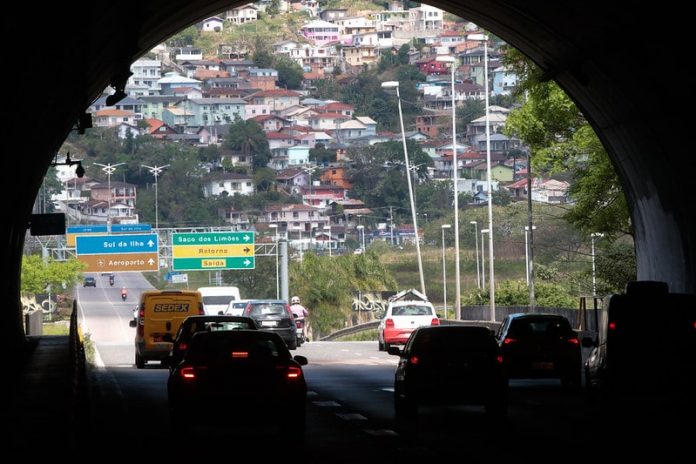 túnel antonieta de barros visto de dentro com carros passando e casas no morro ao fundo