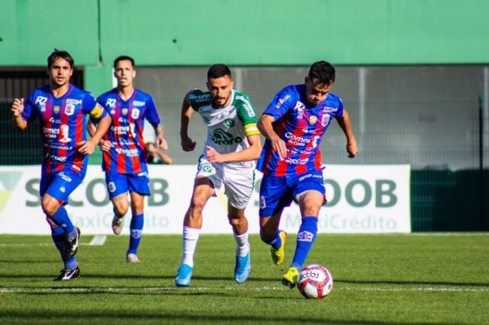 joador da chapecoense corre atrás da bola com outros três jogadores do marcílio dias