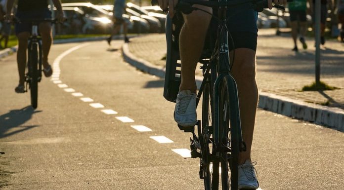 pessoas andando de bicicleta na beira-mar - Decreto estadual mantém medidas contra a Covid-19, mudança nas competições esportivas de rua