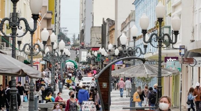 Rua Felipe Schmidt em Florianópolis movimentada com pessoas circulando de máscaras. A foto ilustra a notícia do auxílio emergencial do estado.