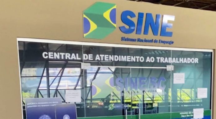 Porta de vidro do Sine, sinalziado em azul, um adesivo de uma carteira de trabalho na porta