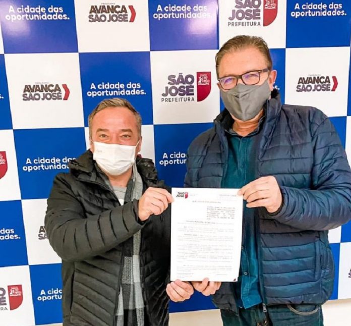 vereador rodrigo de andrade e prefeito orvino usando máscara posam para foto segurando papel da lei de ensino de empreendedorismo em são josé