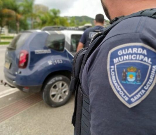 guarda municipal de florianópolis distintivo no braço de agente e viatura ao fundo - criação da corregedoria é aprovada