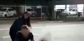 Frame de um vídeo que mostra as agressões de um homem contra outro homem. Na imagem, a vítima é jogada no chão pelo agressor, enquanto uma mulher observa e tenta se aproximar. O caso é tratado como suspeita de homofobia e ocorreu em Jaraguá do Sul.