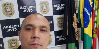 Delegado Manoel Galeno assume delegacia regional de São José - galeno em foto na frente de painel da polícia civil e bandeiras