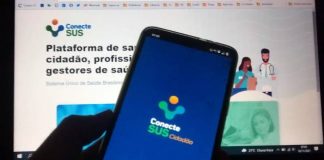 celular com aplicativo conectesus utilizado para comprovante de vacinação em frente a tela de computado com site do conectesus