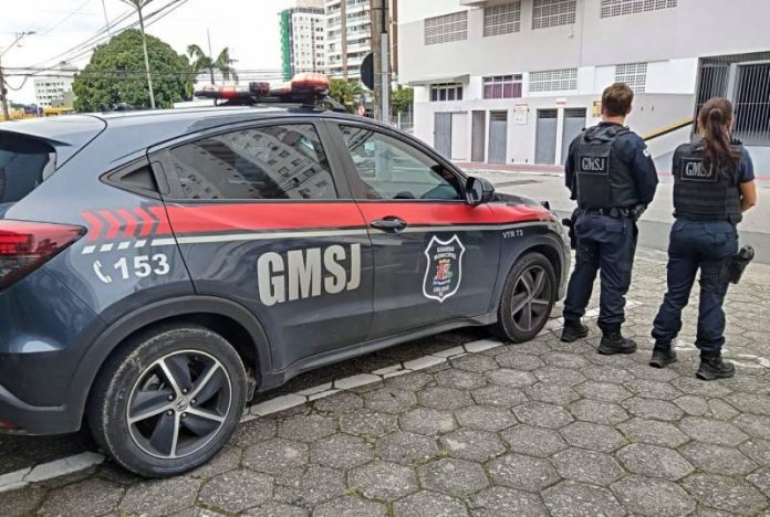 dois agentes da gmsj de costas para foto - Guarda de São José salva garota de 13 anos pendurada no terceiro andar de prédio