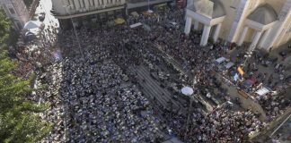 imagem de aérea de centena de bateristas tocando em orquestra no largo da catedral em florianópolis com grande público em volta