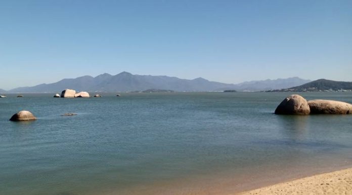 mar da praia de itaguaçu e serra do tabuleiro ao fundo em dia de céu limpo