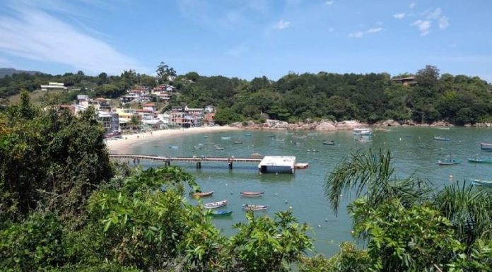 foto de orla de pequena praia com muitos barcos na enseada e trapiche em construção; morros verdes em volta - TCE aponta irregularidades e determina fim de contrato do pedágio ambiental de Governador Celso Ramos