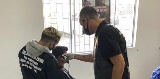 dois homens cortam cabelo de homem em cadeira de barbeiro - Do corte de cabelo à desintoxicação, Centro POP de São José atua na reconstrução de vidas