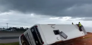 ônibus tombado em 45º no canteiro central sobre lateral direita - Acidente com ônibus de turismo em Laguna deixa criança gravemente ferida