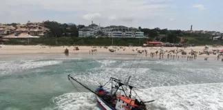 Duas retroescavadeiras tentam rebocar embarcação no Santinho