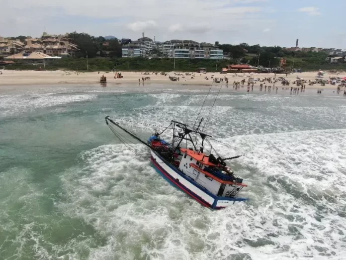 Duas retroescavadeiras tentam rebocar embarcação no Santinho