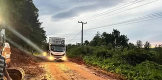 caminhão passando por parte da pista da sc-108 ao lado de queda de barreira