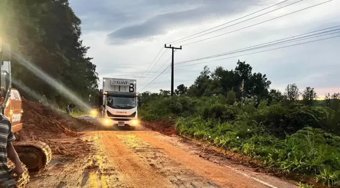 caminhão passando por parte da pista da sc-108 ao lado de queda de barreira