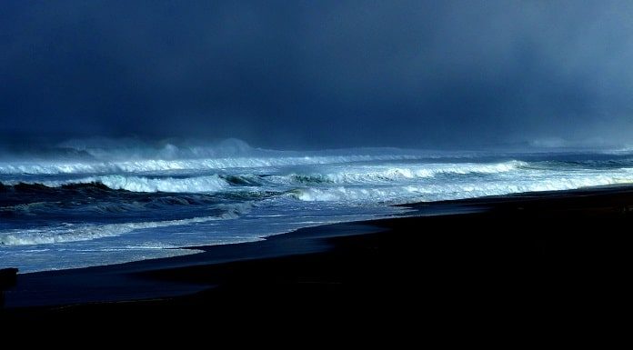 foto de uma praia no início da noite com mar agitado e muitas nuvens - previsão do tempo de chuva em sc